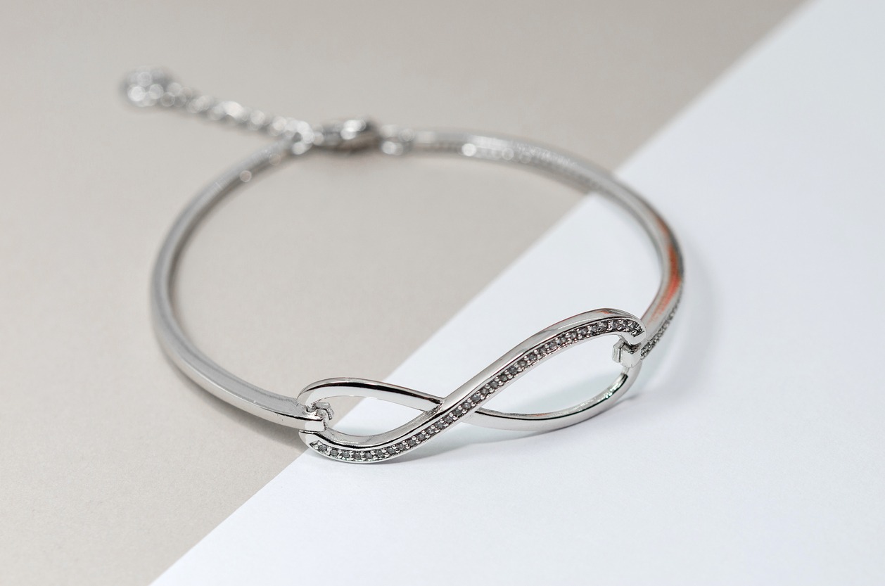 silver infinity bracelet with diamonds in white and toffee background