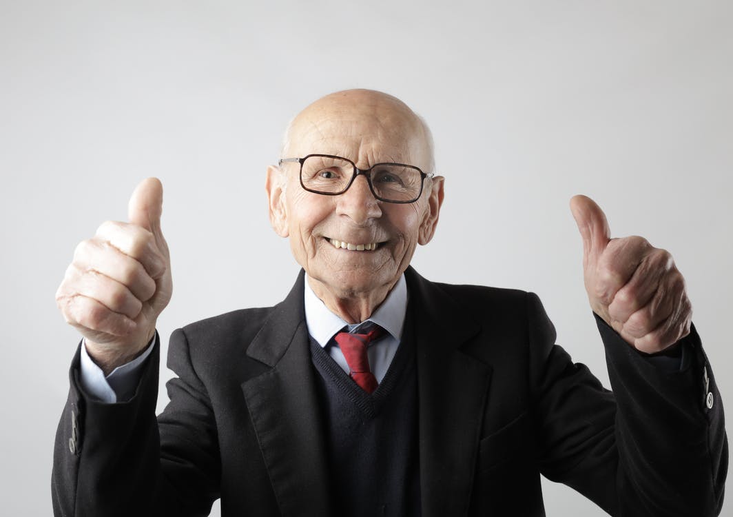 Positive Senior Man in Eyeglass Showing Thumbs Up and Looking at the Camera