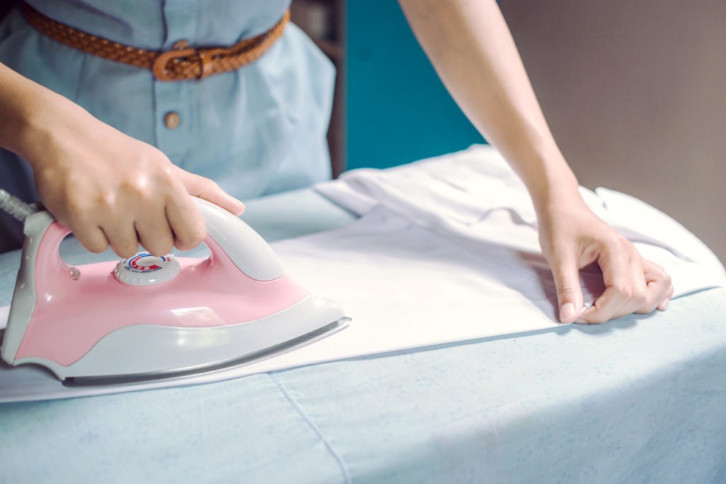 woman hand ironing shirt