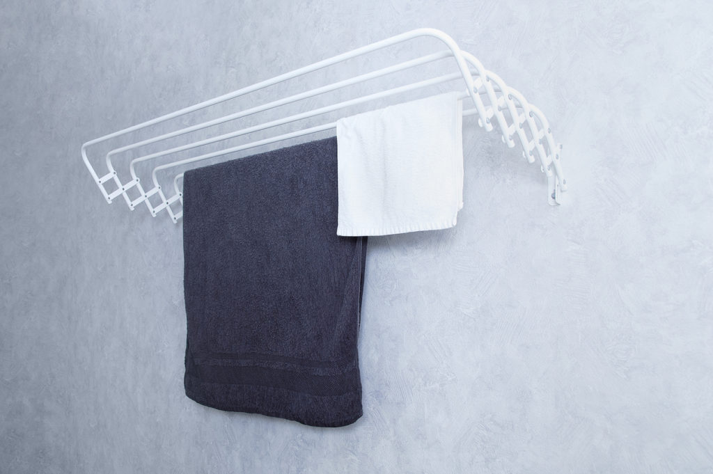 White metal wall-mounted clothes dryer with towels