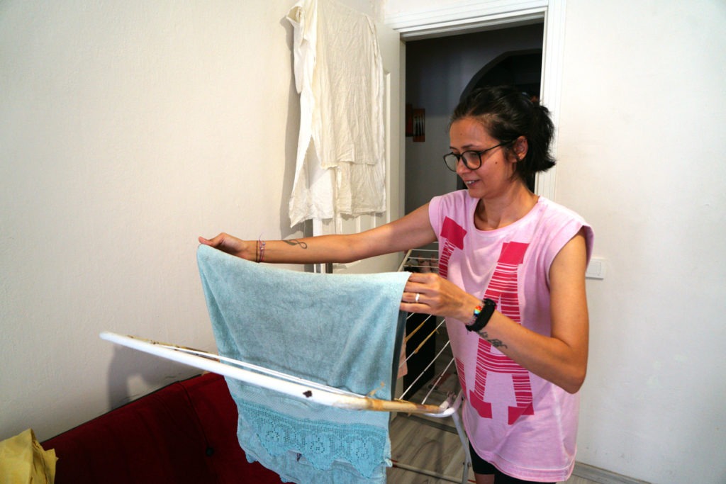 Woman drying clothes on a laundry drying rack