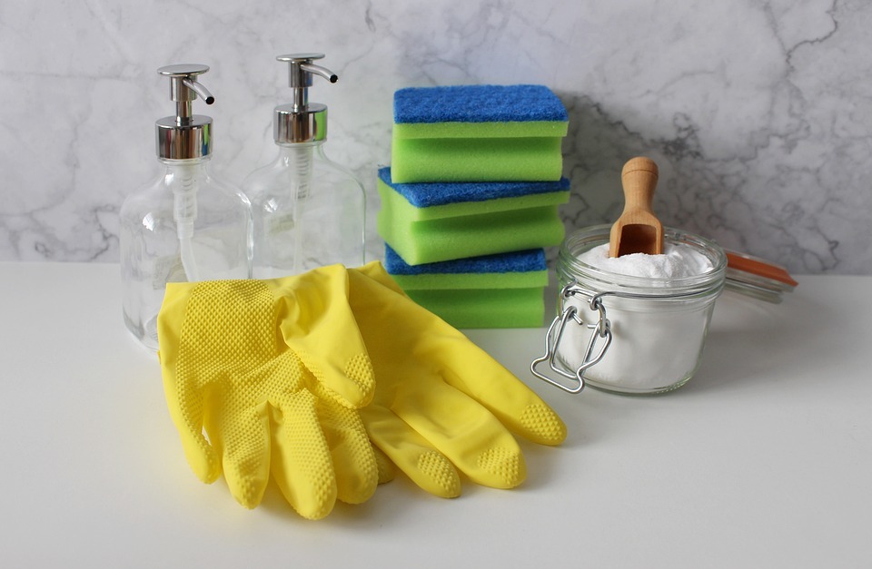 refillable soap dispensers, gloves, three sponges stacked on each other, powdered soap in a glass container with a wooden scooper