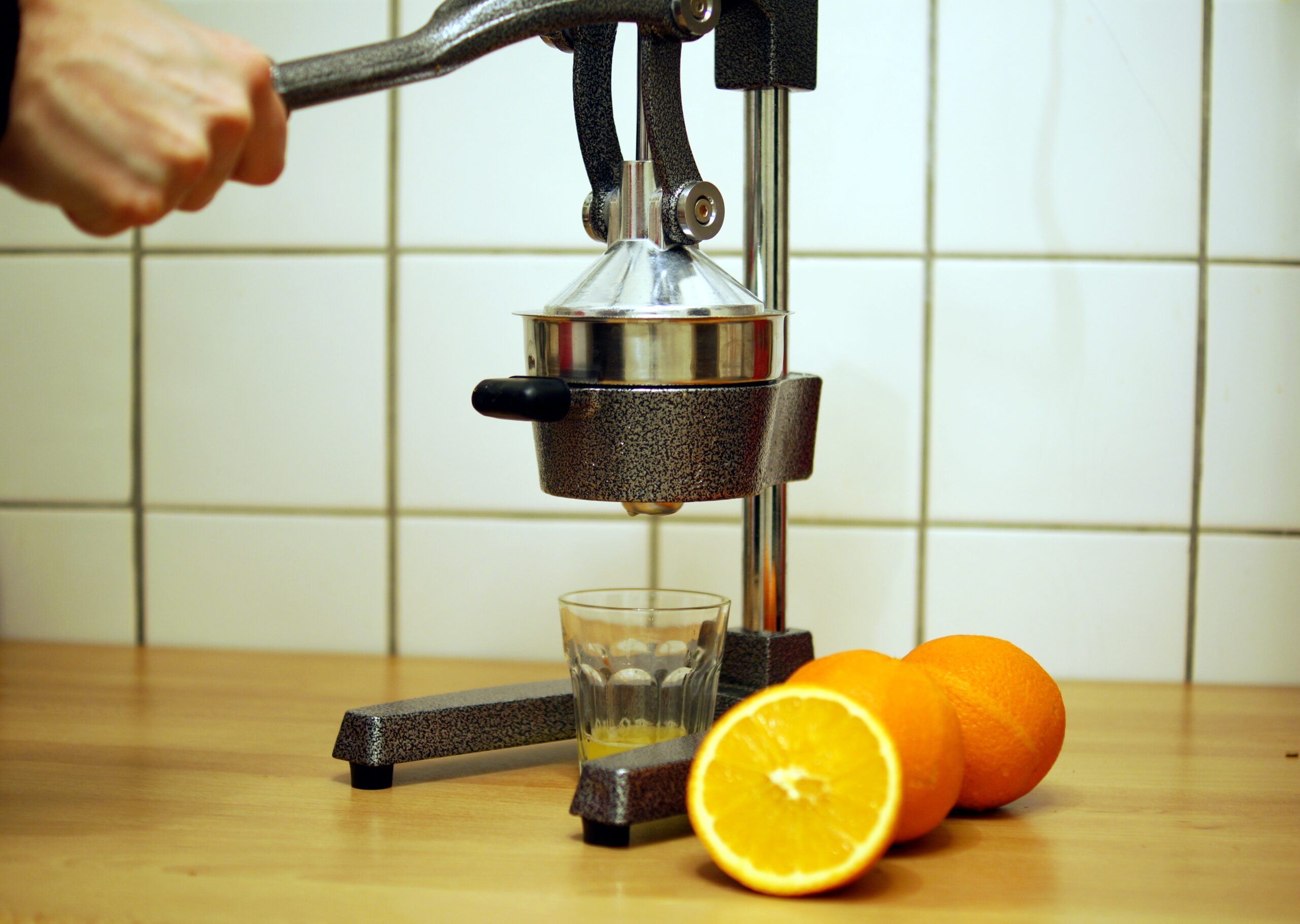A juicer with a glass of orange juice