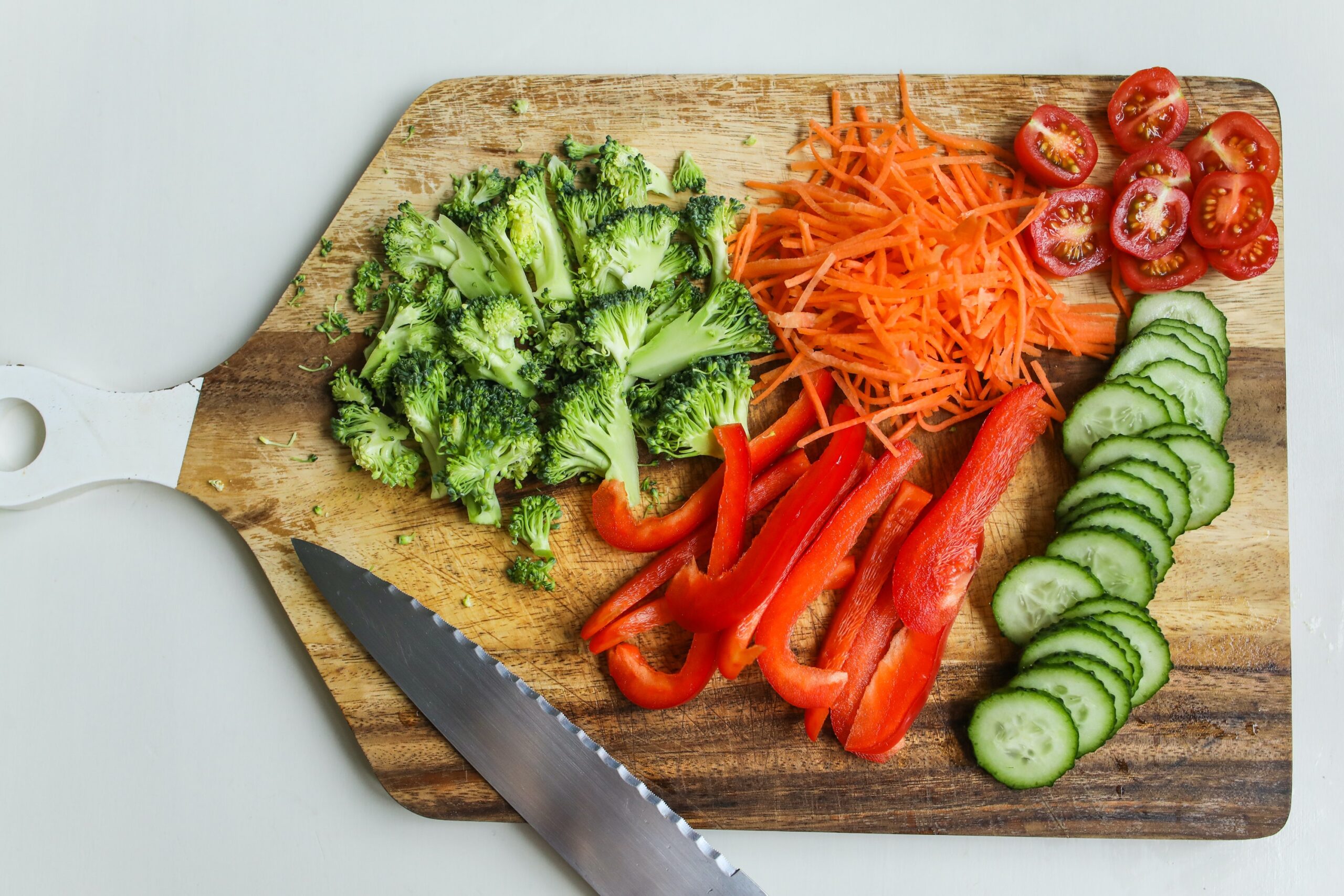 A wooden cutting board with vegetables on top
