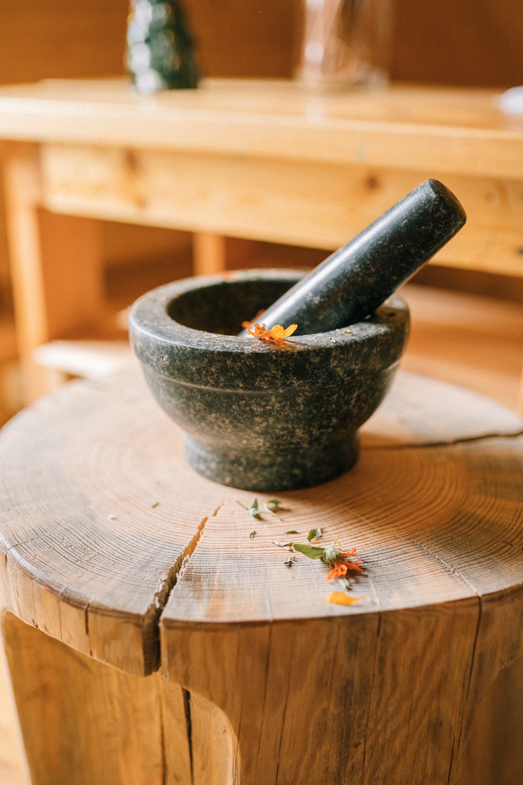 A wooden mortar and pestle with whole black pepper and ground pepper