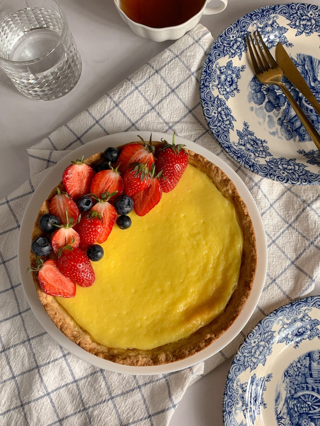 Close up of a lemon tart topped with fruit:
