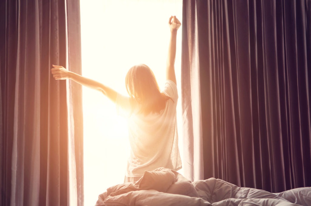 Woman waking up with the sun
