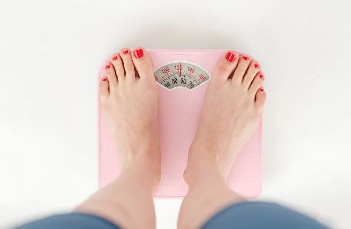 Woman with weighing machine