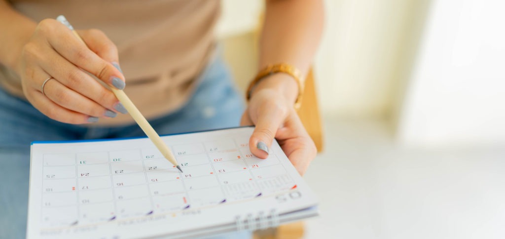Woman writing a schedule on a calendar