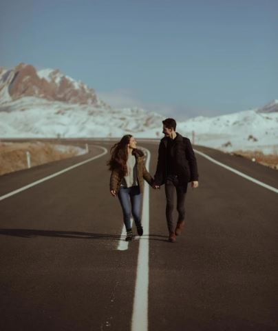 a picture of man and woman walking on the road