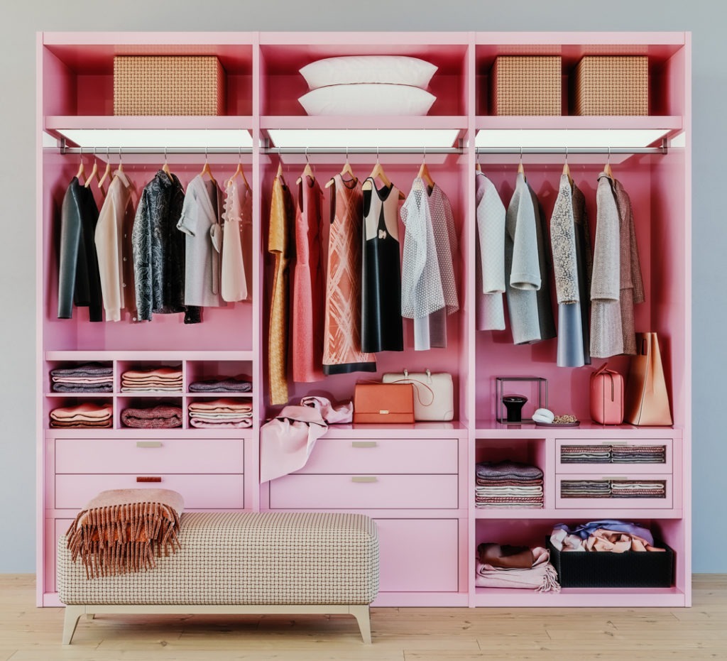 modern pink wardrobe with clothes hanging on rail in walk in closet design interior