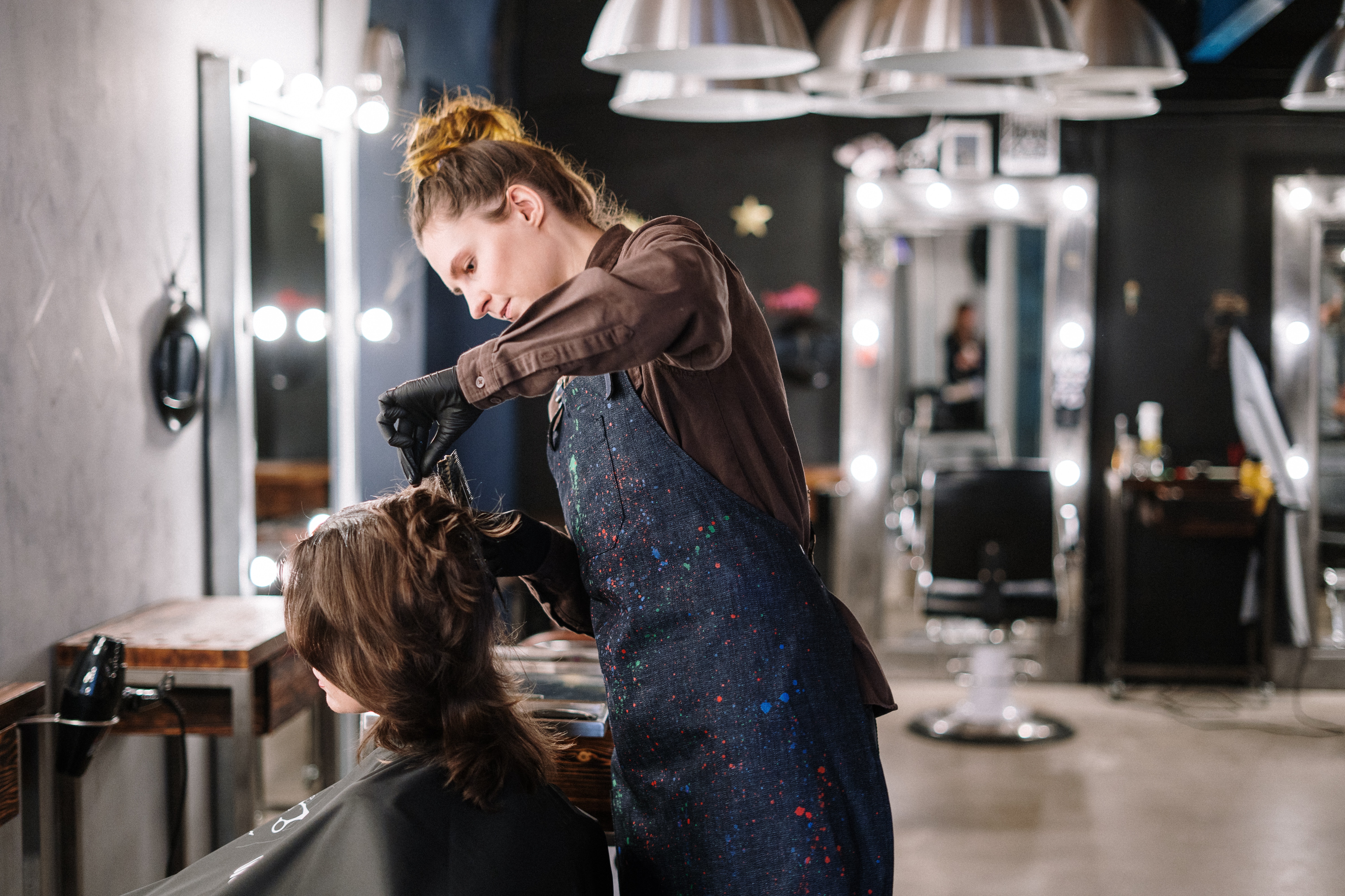 a hair stylist cutting the hair of a woman