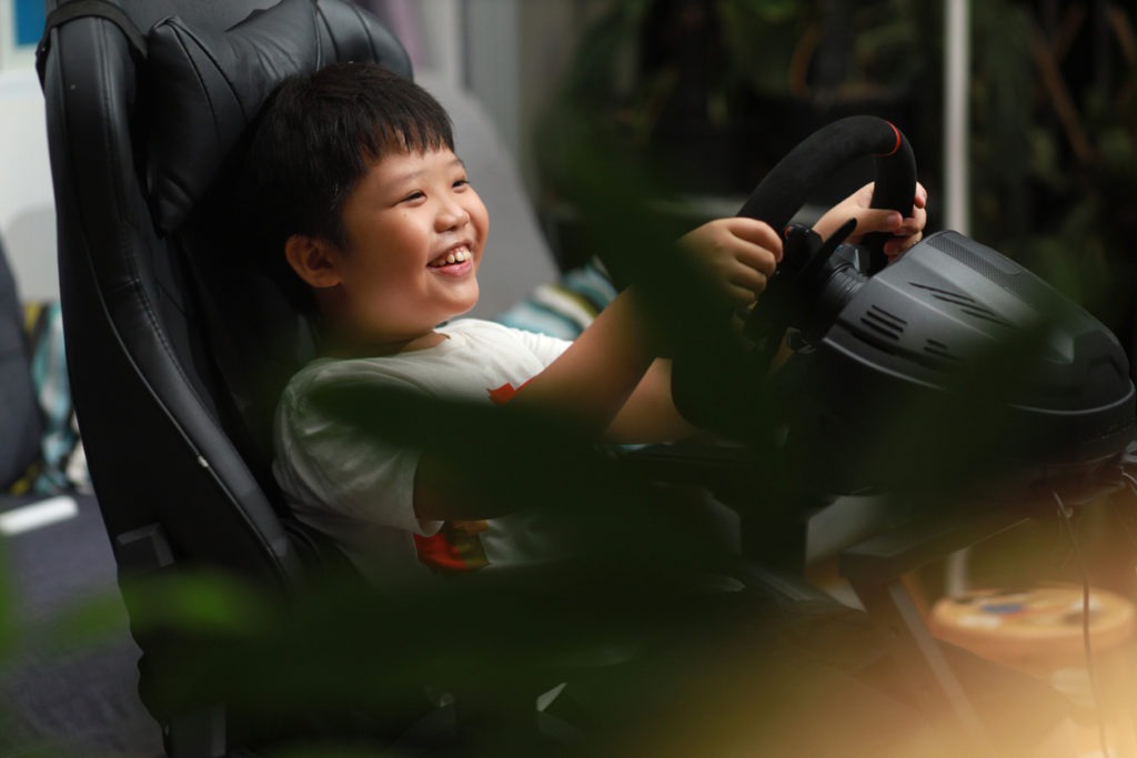 Little Asian Boy Enjoying Car Racing Video Game