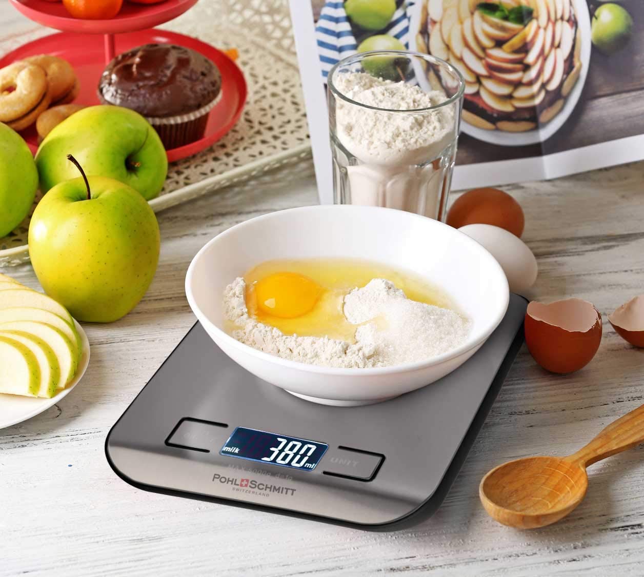 A kitchen scale on a table along with other things