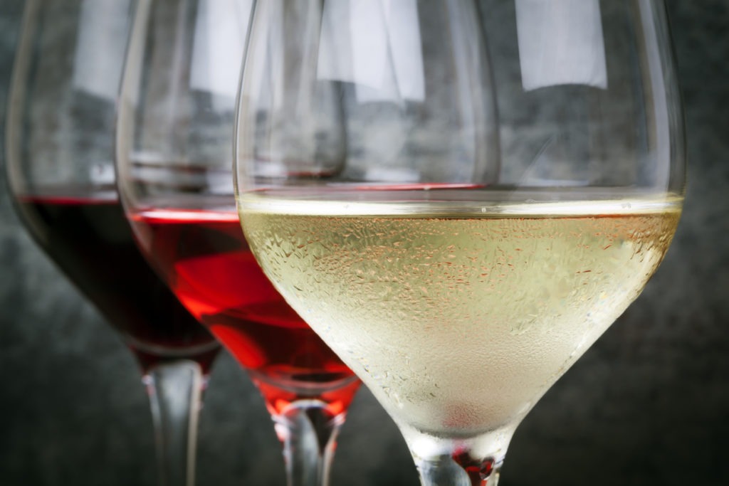 Glasses of white, rose, and red wine. Focus on the foreground