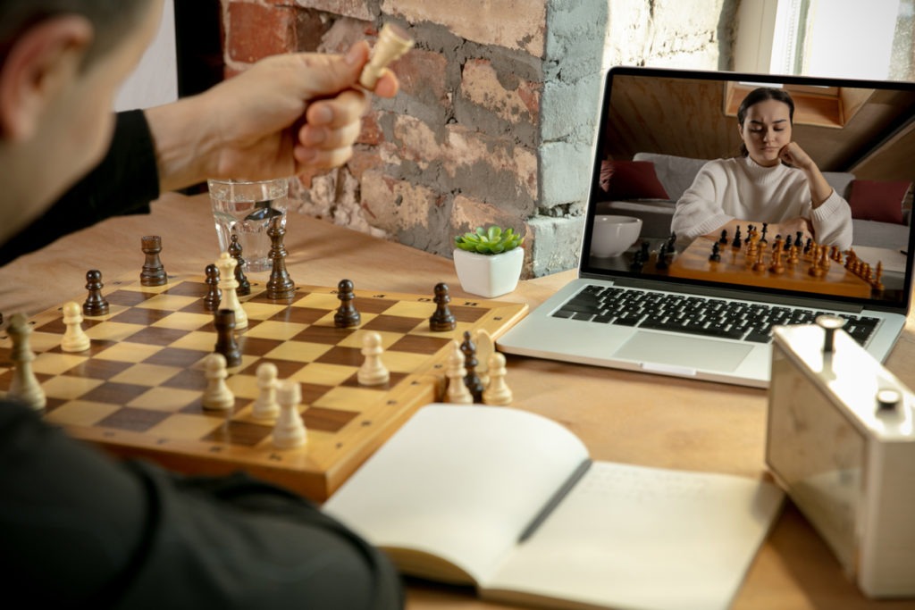 Caucasian man chess player playing chess online with his student