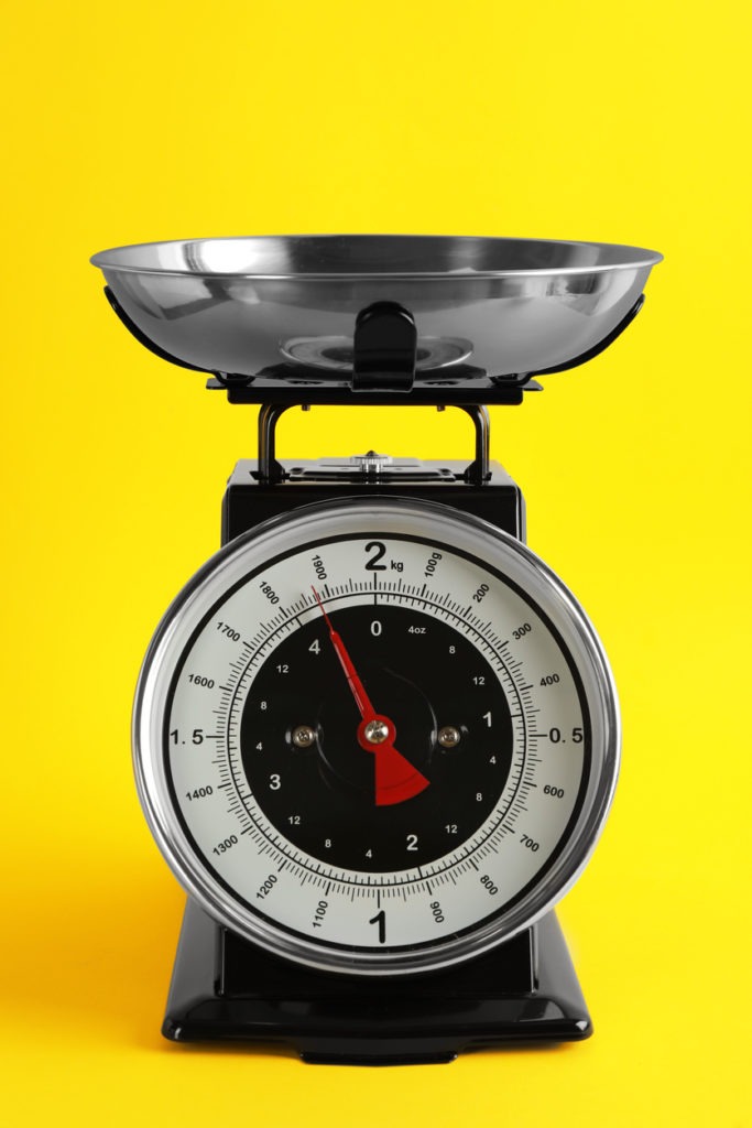 Retro mechanical kitchen scale on yellow background
