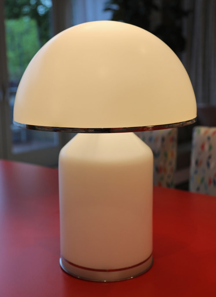 Mushroom shaped glass white lamp stands on red table
