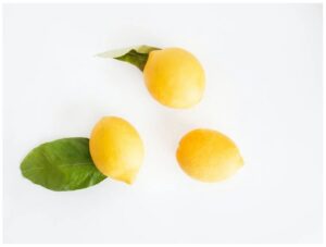 one full and one sliced lemon on a leaf