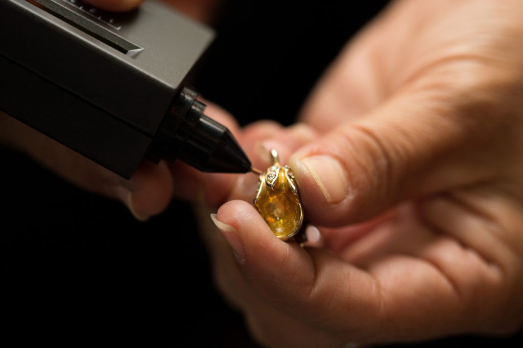 A jewelry being tested by an electronic gold tester.