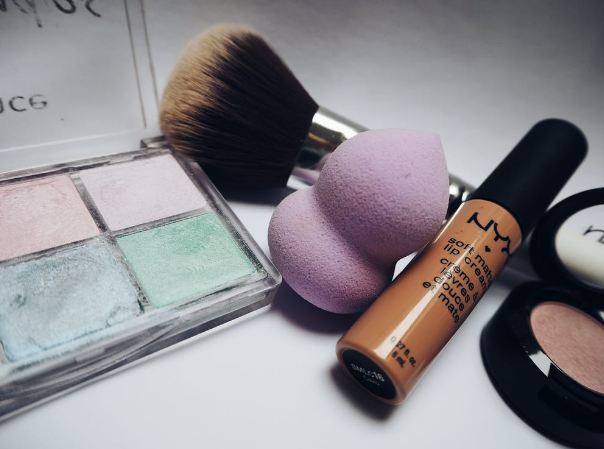 a makeup sponge together with other makeup products