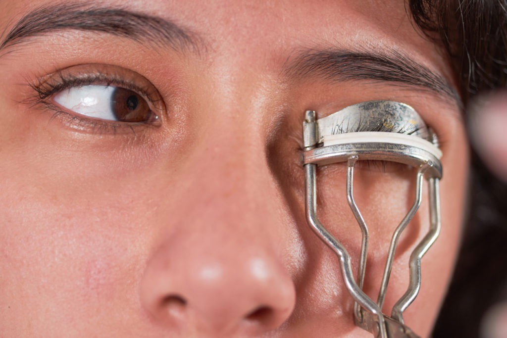close-up macro of using eyelash curler