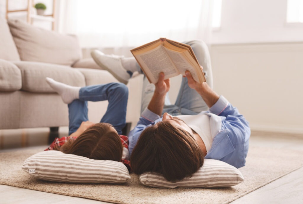 A dad reading a book with her daughter