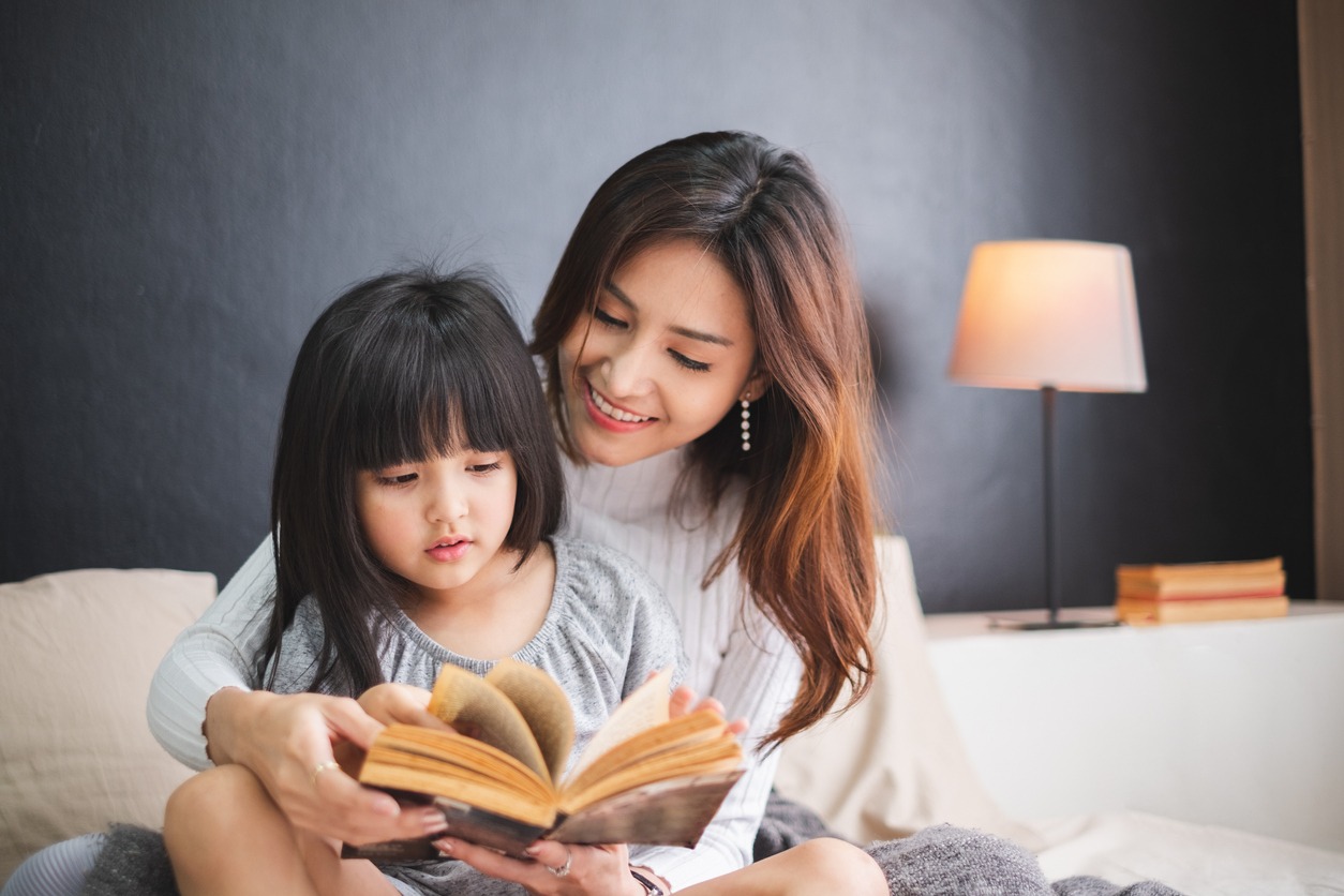 A mother reading a book to her daughter