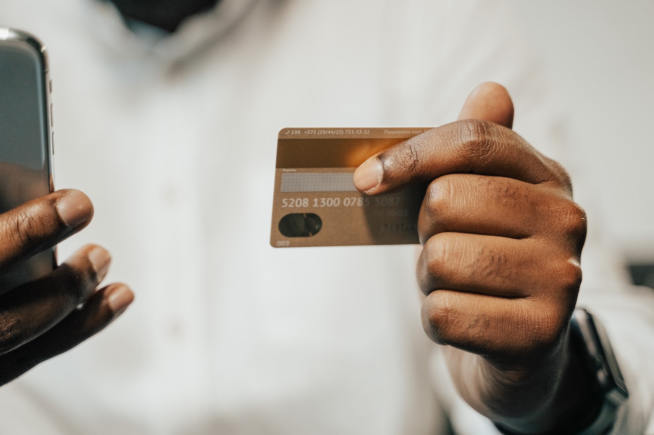 a mobile and a credit card in a person’s hands