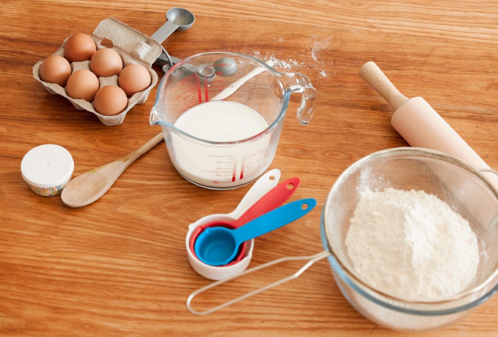 Baking ingredients and kitchen utensils on a wooden table