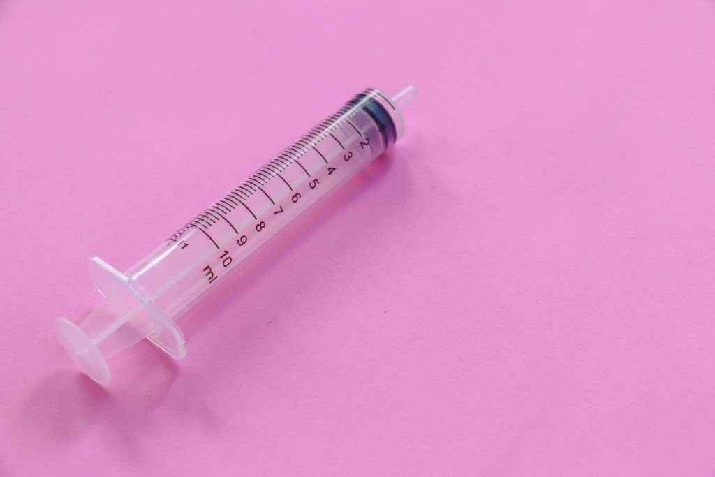 Syringe on a pink background