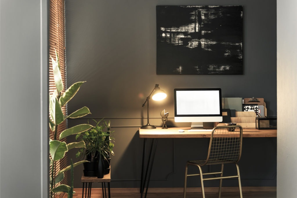 A small home office lit by a table lamp