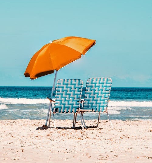 Two beach chair and an umbrella by the seaside
