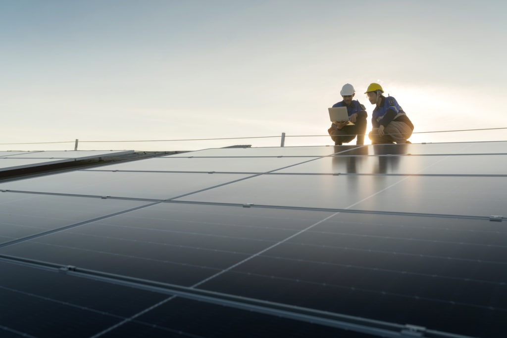 Workers working among solar panels.