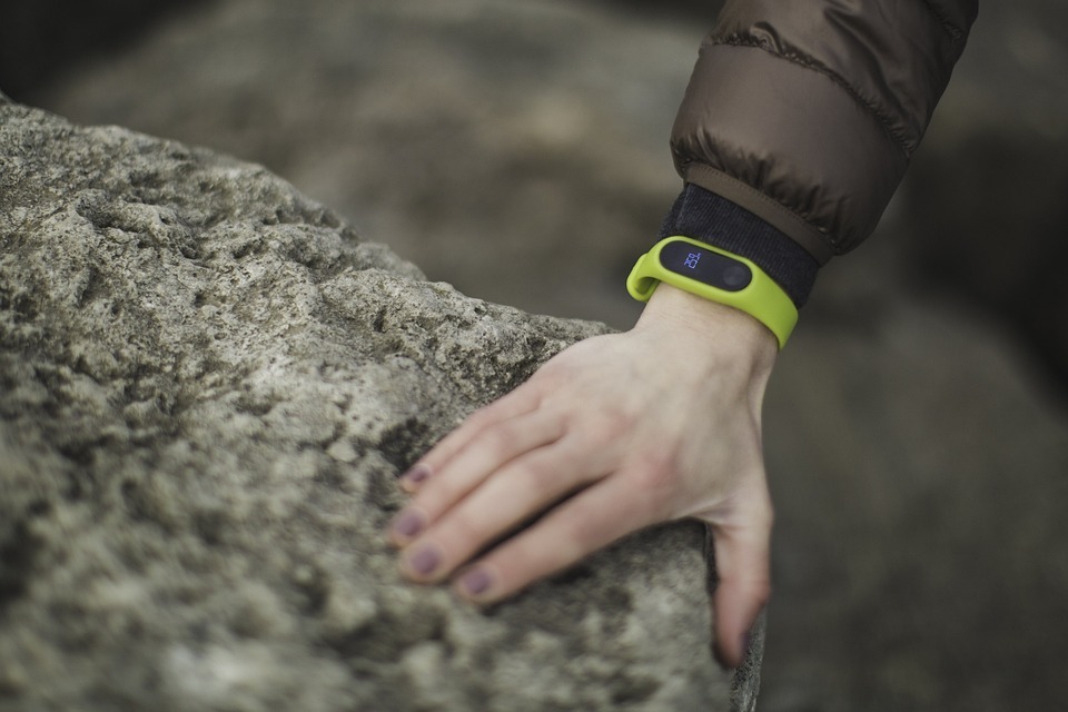 A green Fitbit in a person’s wrist.