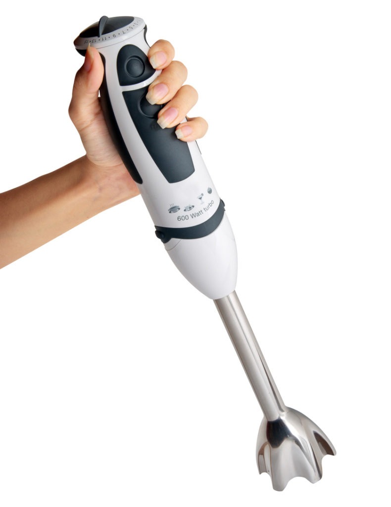 A woman hand holding an immersion blender