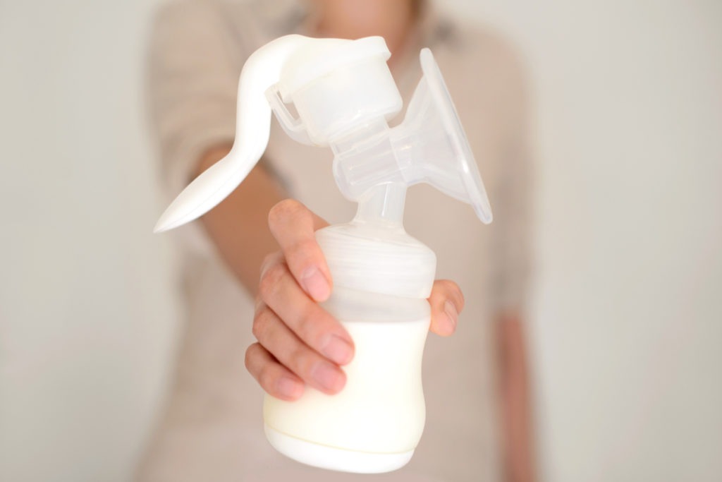 A woman holding a manual breast pump