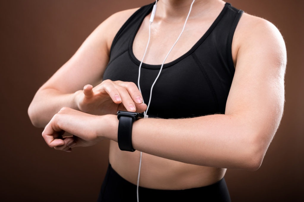 A woman wearing a Fitbit on her wrist.