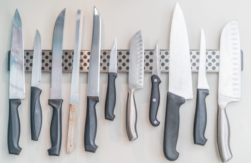 Domestic kitchen knives arranged on a magnetic knife rack