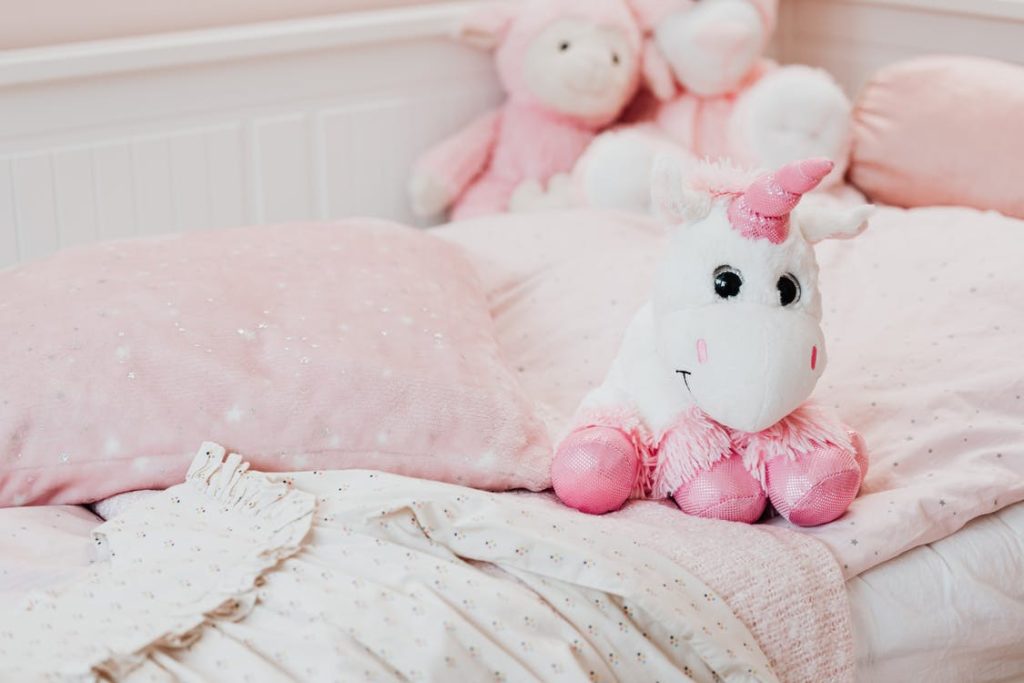 Image-of-a-baby-unicorn-toy-and-sleeping-essentials-like-pillows-and-comforter.-1024x683
