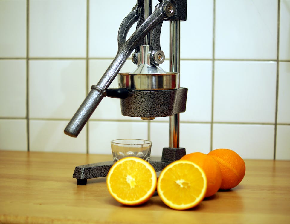 Oranges beside a juicer