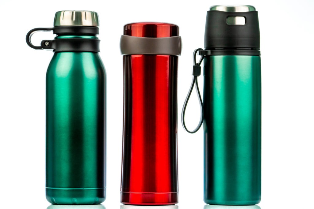 Thermos bottle isolated on white background. Coffee or tea reusable bottle container. Thermos travel tumbler. Insulated drink container. Red and green stainless steel thermos water flask. Zero waste