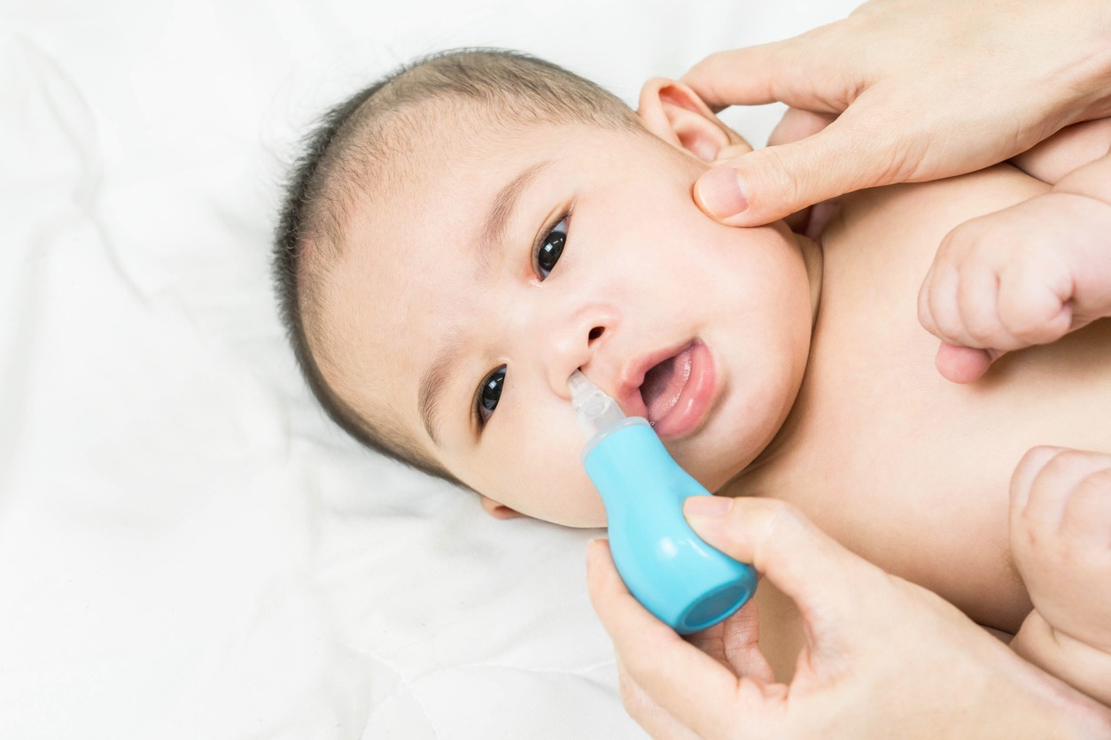 Using a nasal aspirator on a baby
