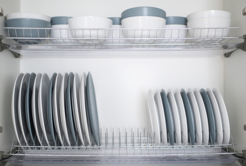 White and gray plates are stacked for storage in the kitchen