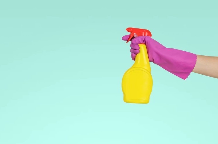 a-person-holding-a-yellow-spray-bottle