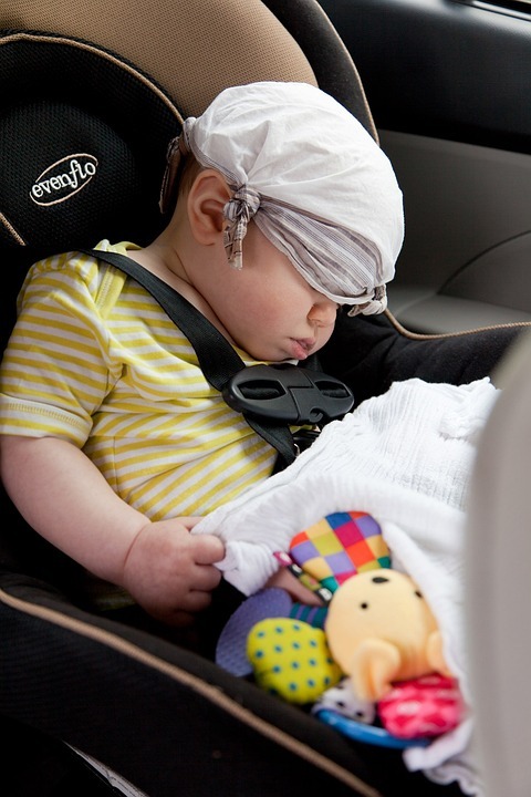 a-sleeping-sitting-in-a-booster-seat-while-holding-toys