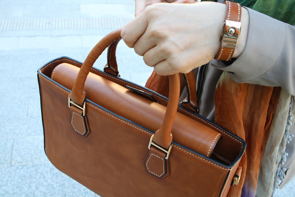 a woman holding her brown leather bag