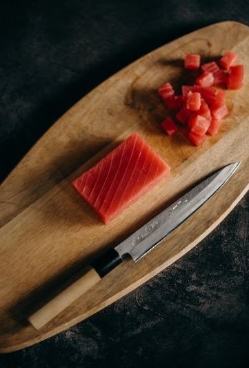 diced meat and knife on top of a chopping board