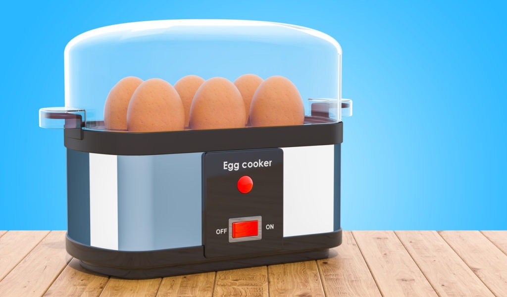 Egg cooker or egg boiler with eggs on the wooden table. 3D rendering