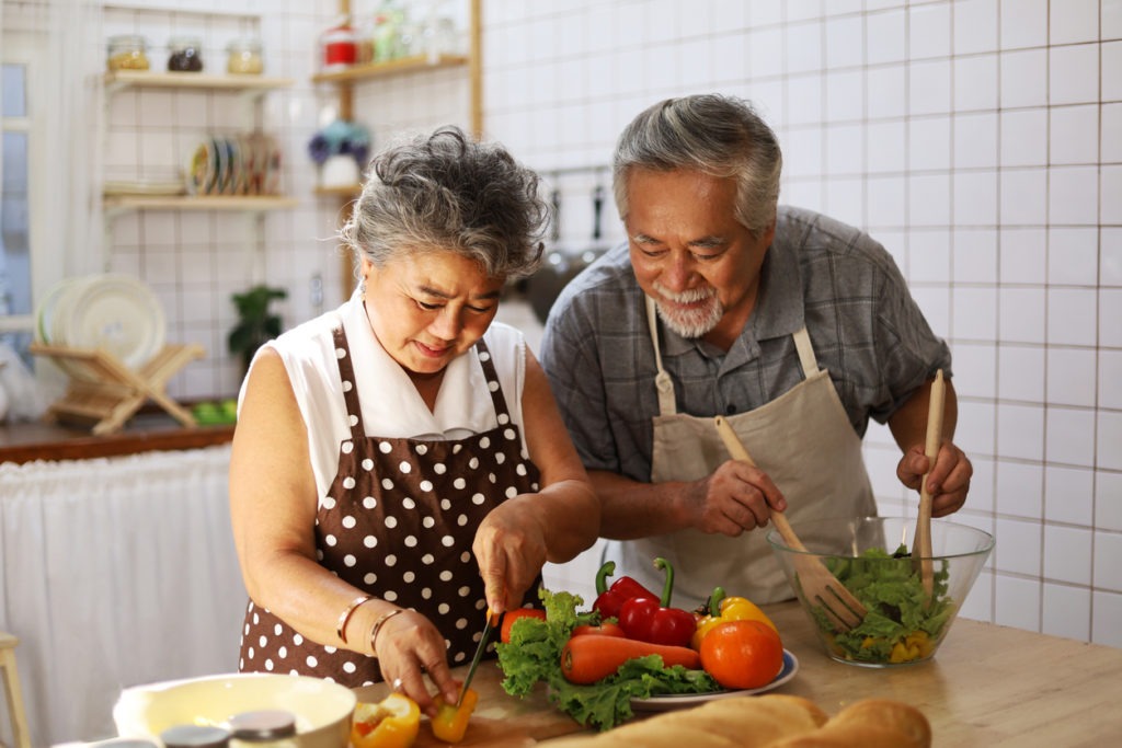 elderly couple preparing vegetables